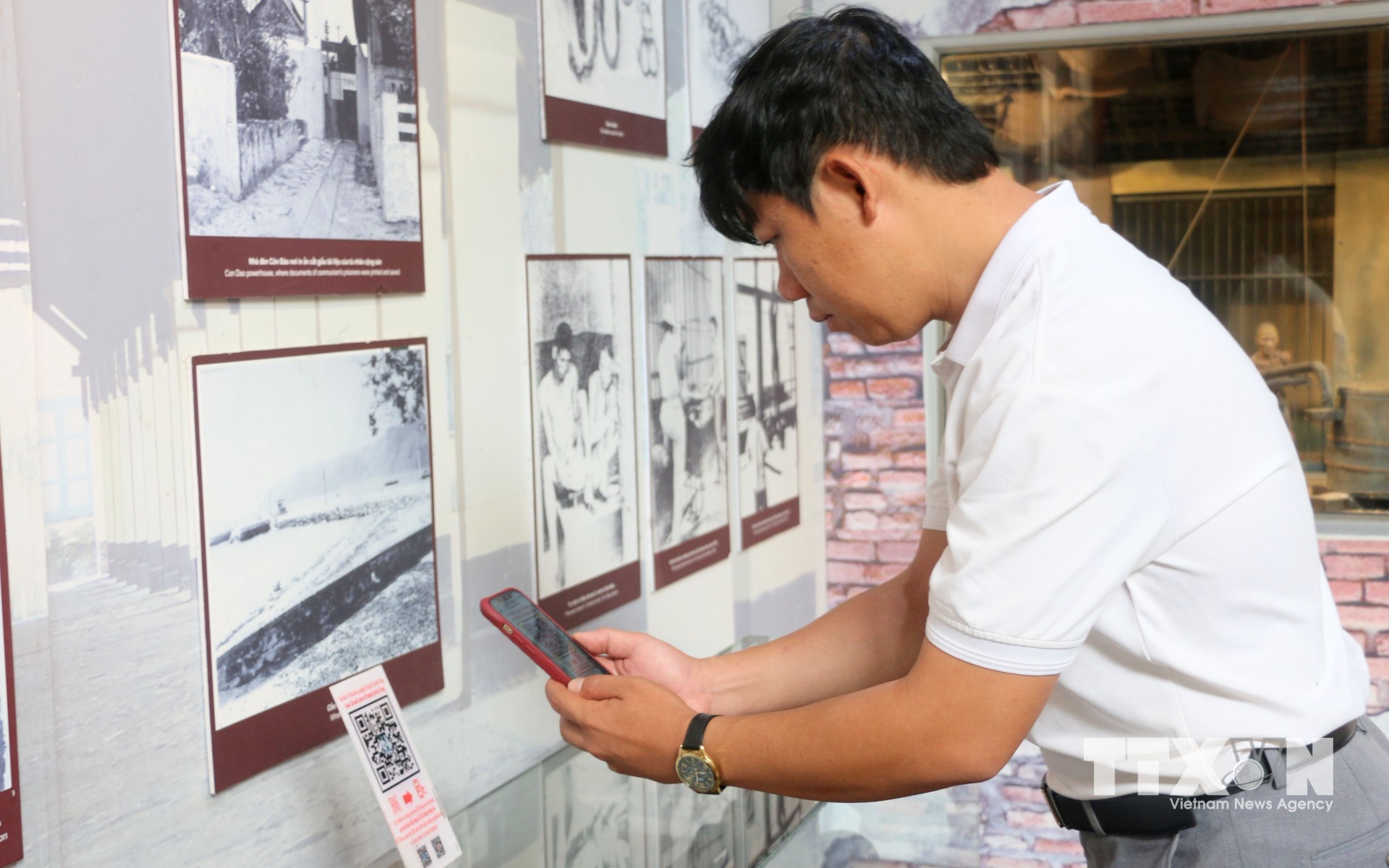 Du khách quét QR để tìm hiểu thông tin tại Nhà trưng bày thân thế, sự nghiệp Chủ tịch Tôn Đức Thắng, nằm trong Khu lưu niệm Chủ tịch Tôn Đức Thắng, thuộc xã Mỹ Hoà Hưng, tỉnh An Giang. (Ảnh: Công Mạo/TTXVN)